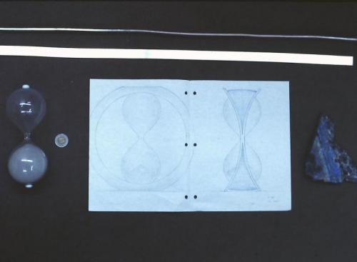 A drawing of the design and the main raw materials: rectangular rods of sterling silver, the hour glass, and a sample slice of the multi-coloured labradorite.