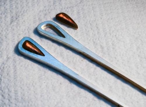 Vertical-sided openings in the metal are very precisely cut to the outline of the stones. After an exact fit is achieved, a sterling "table" is soldered into the back of each opening.