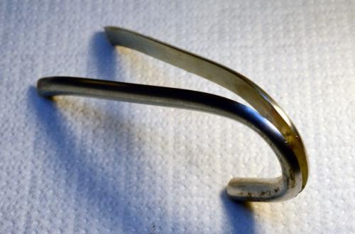 Beginning to bend the half-round portions of the wire, bending against the direction of their cross-section.