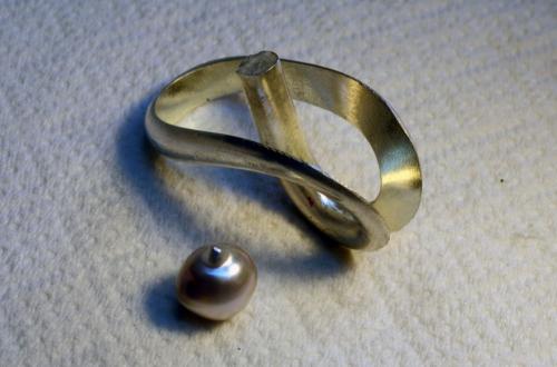 Ring shank is joined, and the entire form is filed true. A post will be soldered into the ring onto which the pearl will be set. This post will be "barbed" with engraving tool stitch-marks. The pearl will be drilled as to fit tightly against these "barbs." The pearl will then be locked in place with epoxy.