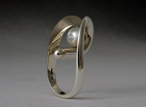 The finished piece, polished, with the pearl in place.