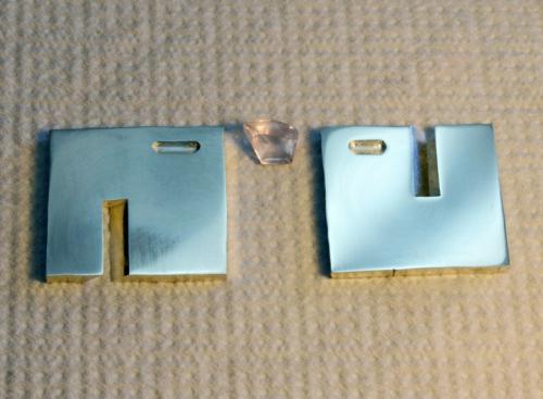 Two square sheets of sterling are precisely slotted in order to fit together as an X. Two carved areas are exactly positioned to receive the edges of the stone. What will become the inside surfaces are pre-polished.