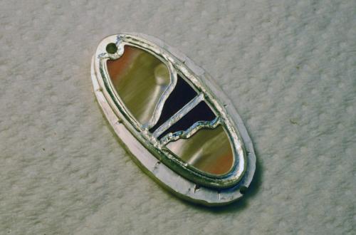 Here we see how the metal is “upset” and “flowed” over the beveled edges. The metal mechanically secures the shell and wood next to their visible surfaces.