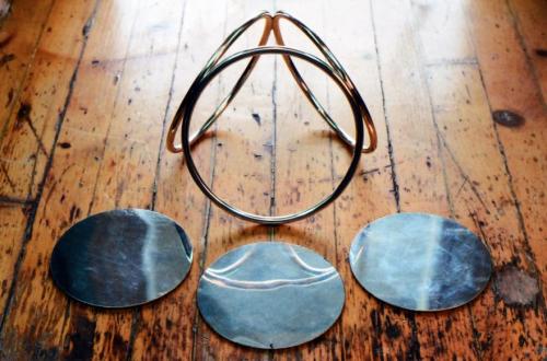 The constructed pyramid of sterling circles, and three sterling discs that will become the drip-catches.