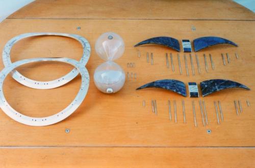 This photo shows all the parts ready for final assembly. There are 34 rivet wires, four labradorite arcs, two units with yin-yang symbols, the sterling framework, and the hour glass sand-timer.