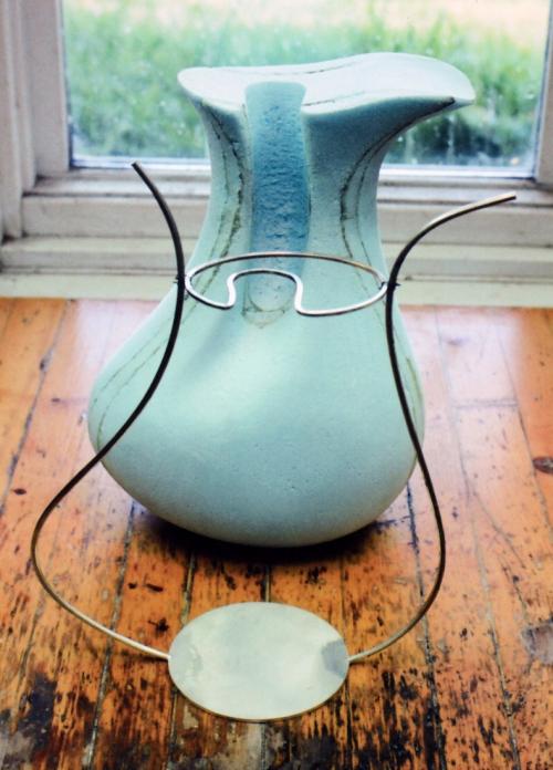 The beginning. A styrofoam model was made as a guide to the form. The first 2 wires are soldered to the base (the wires are 1/8" in diameter). A template is temporarily attached at the narrowest area of the neck.