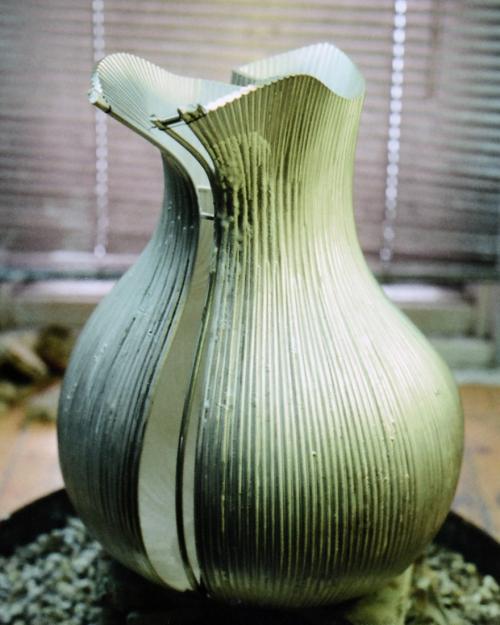 The pitcher is shown ready to be soldered. The wire to be attached is tied with binding wire at the top with a temporary spacer in place. Flux can be seen dried in the area of the join. Under heat, the flux becomes glass-like which keeps the metal clean and helps the solder flow.