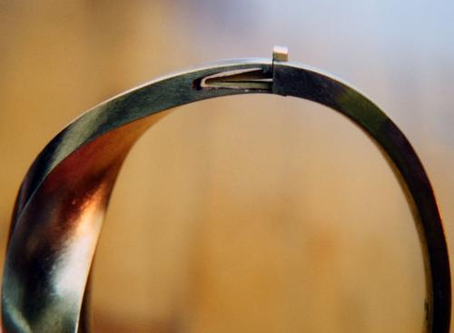 The spring has been soldered precisely in place and its step "locks" perfectly within the cut out area. There is also room for the spring to be pressed to release the catch. With a temporary wedge-shaped support placed within the spring, its very end is lightly hammered to harden it enough to give it spring tension.