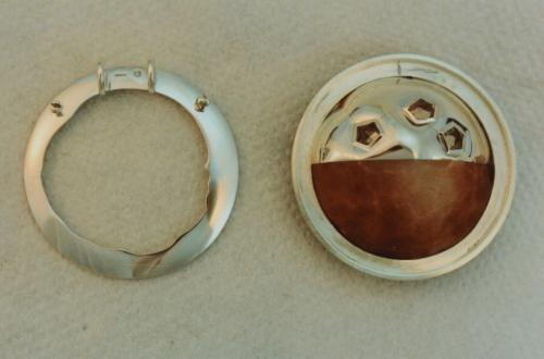 Seen from the back, the two halves are shown precisely fit together into the circular frame, and the conforming collar with bevelled edges is ready to be bezel set by the circular frame.