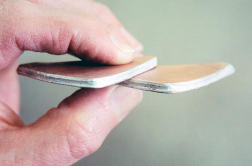 The stacks, smithed out like pancakes, are now heavy sheets. The edges have been coated with solder. All the contrasting layers of metal are still contained within the mokume.