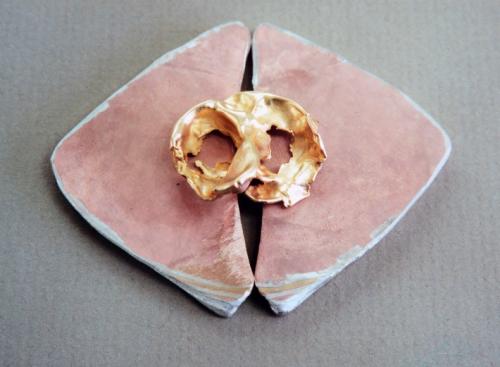 Placed upon the two sheets is a 14 k. yellow gold watercasting (the random result of dropping molten metal in water). While being smithed, some of the internal mokume layers have become exposed at the surface (lower corners).