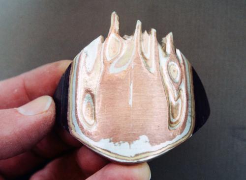 More carving into the mokume to reveal pattern. More random edge along the top is cut away while the higher points are actually bent up beyond the original edge. During this bending, the bond between the mokume layers remained 100% strong.