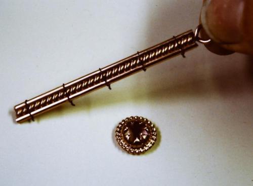 The three strands of wire (two straight and one twisted) are bound together with fine steel wire to be soldered together. The contacting surfaces between the wires have been flattened slightly.