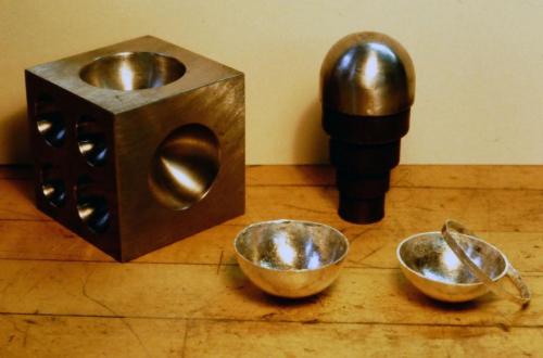The two halves are trimmed and soldered together to create a spherical shape.
