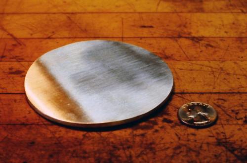 A portion of the ingot is rolled to a 1/8" thickness and cut to a 3" diameter disc.