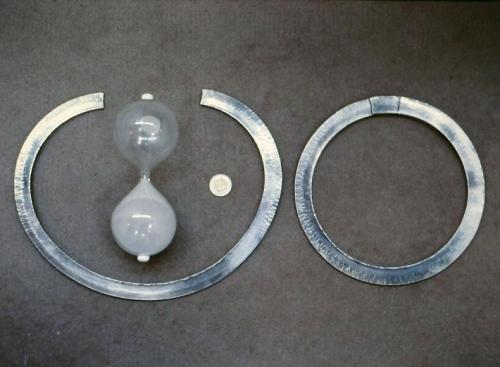 One rod has been forged into a circle and the other is closing in. The hammer mark-off on the finished circle clearly shows how the outer edge of the metal has been worked the most.