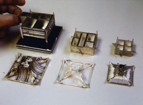 Here the component parts shown in the previous image are separately laid out. The rivet wires at the corners of each layer of drawers are easy to see.