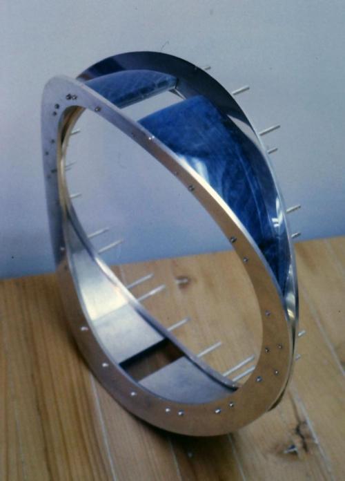 All 12 panels of labradorite have been backed with sterling (with rivet tubes attached). They are seen here finished and temporarily locked into place by rivet wires. Final cutting and polishing of the curved labradorite surface was done with the panels epoxied end to end so as to create as seamless a contour as possible.