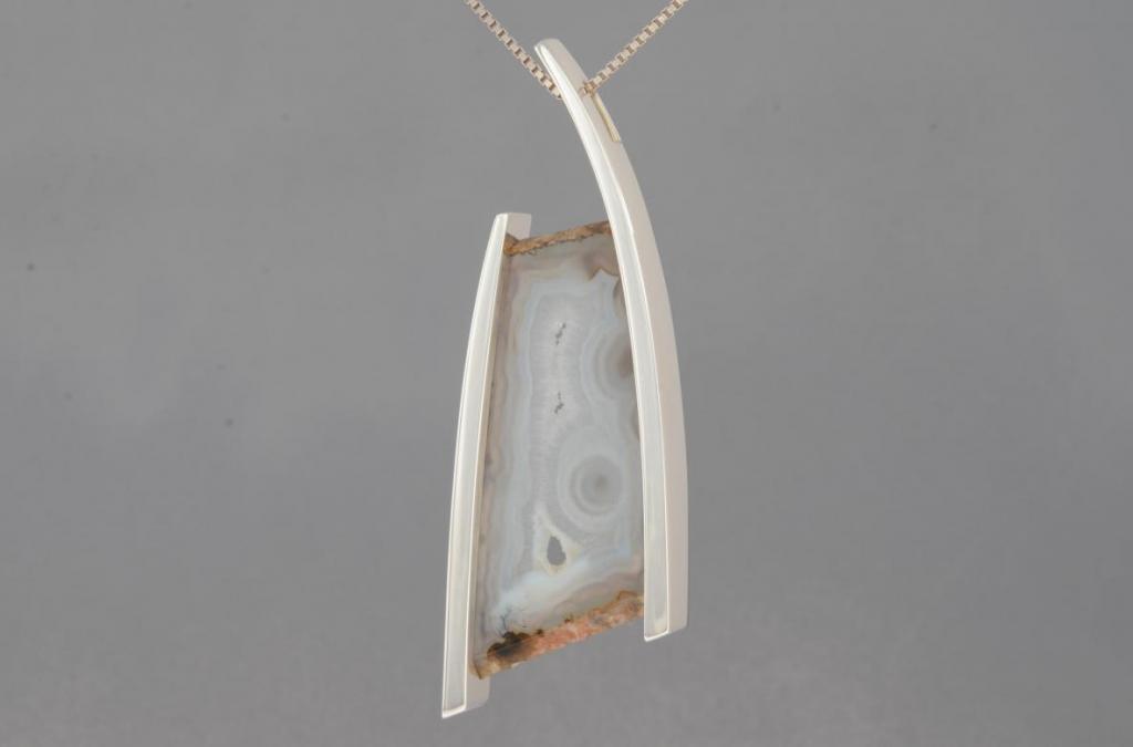 Simple floating design with gray and white agate, set indirectly with rivets through tubing on the back